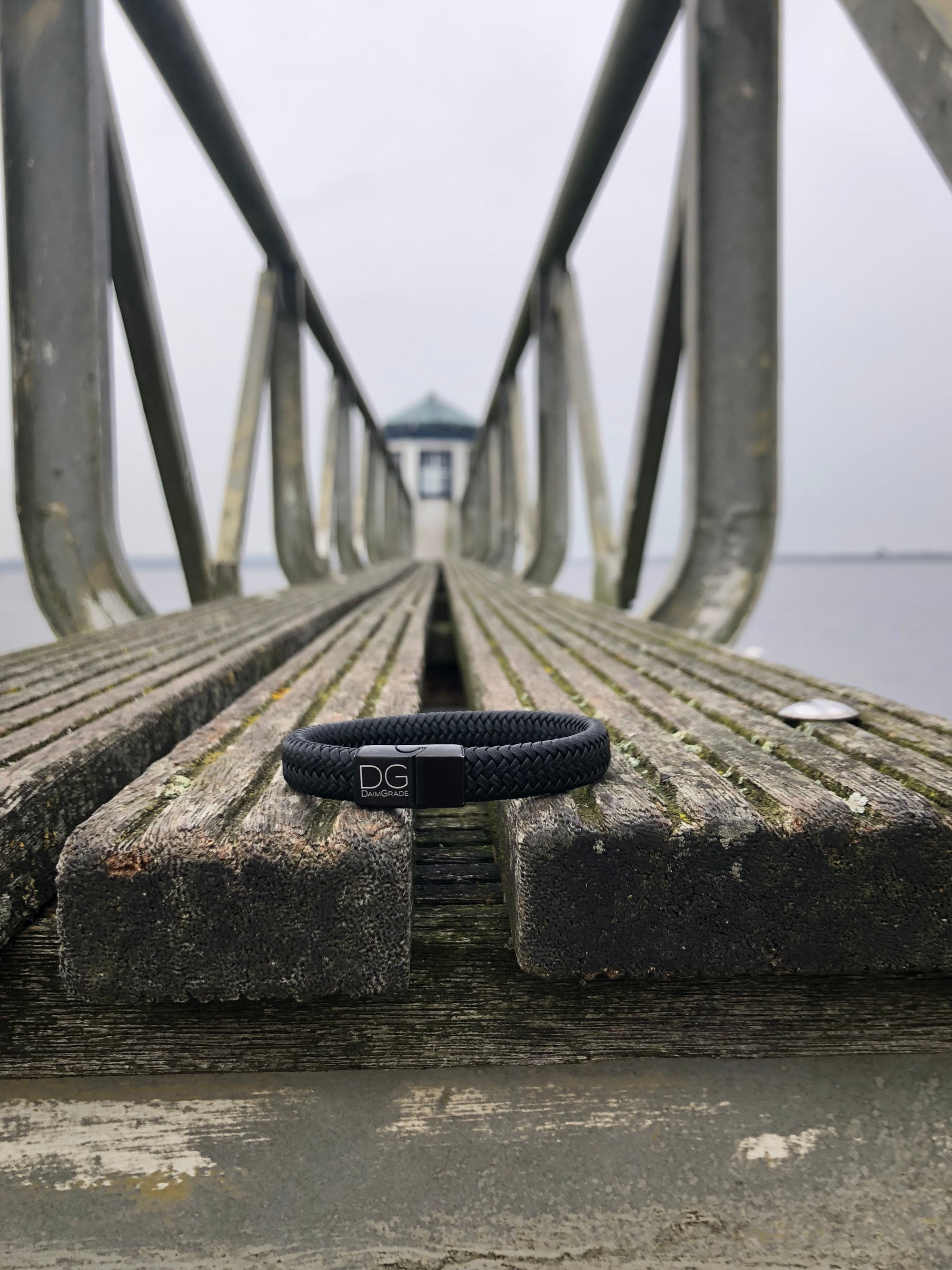 Een daimgrade armband die op een brug ligt bij een vuurtoren