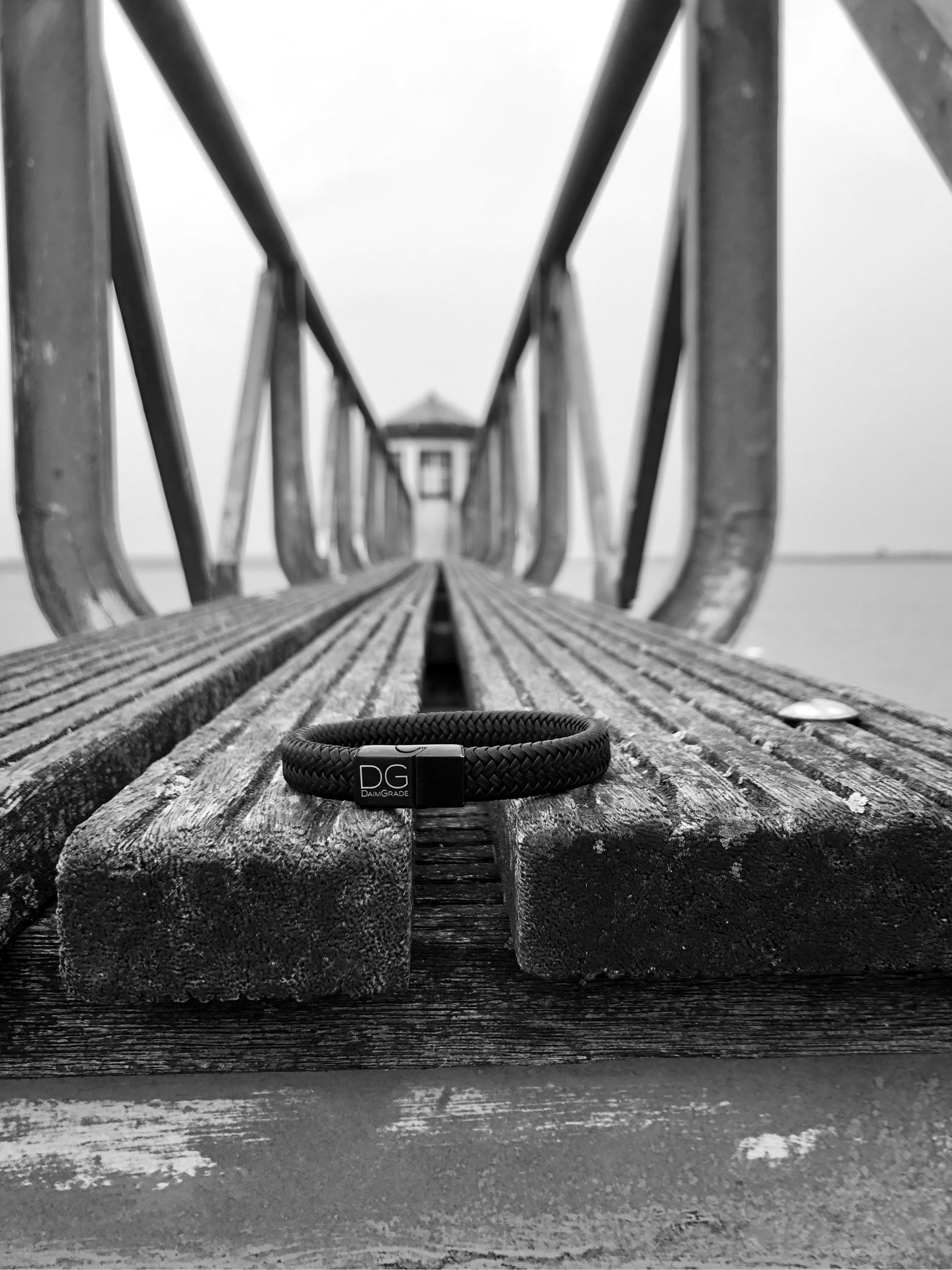 Een daimgrade armband die op een brug ligt bij een vuurtoren 